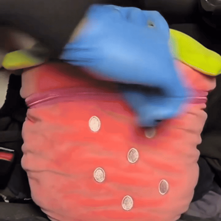 Bunny Berry™ plush being pulled out of strawberry storage pouch – showcases surprise and multifunctionality.